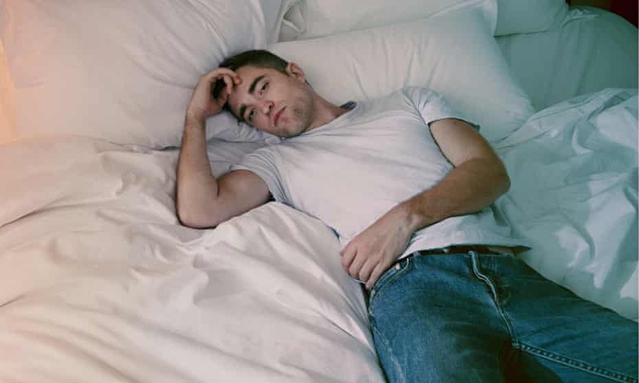 robert pattinson lying on a hotel bed