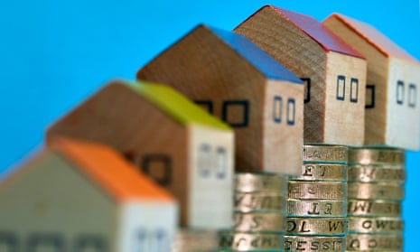Wooden houses on increasing piles of pound coins