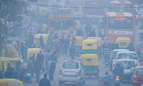 Indian commuters travel on a polluted road near a bus terminus in the Anand Vihar district of New Delhi. Photograph: AFP/Getty
