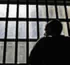 19 year old inmate James looks out of the window of the Young Offenders Institution attached to Norwich Prison on August 25, 2005 in Norwich, England.