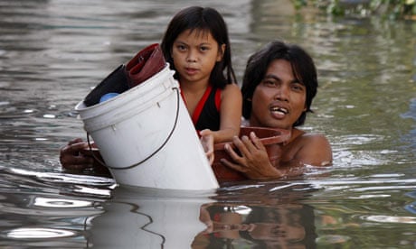 Man and his daughter struggle though floodwater in Philippines