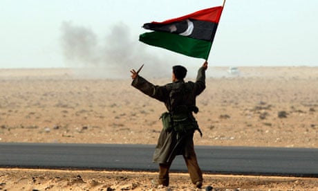 Rebel fighter holds a Kingdom of Libya flag