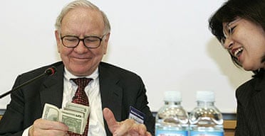 Warren Buffett counts the money from his wallet after an employee asked how much money he had in it, during a meeting with workers of TaeguTec, in Daegu, South Korea.