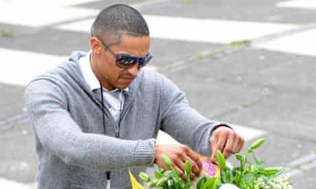 A man leaves flowers outside Marlborough Grange, Leeds, where Pat Regan was killed yesterday