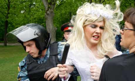 A Russian policeman detains a man dressed in a bridal gown during a gay rights protest in Moscow