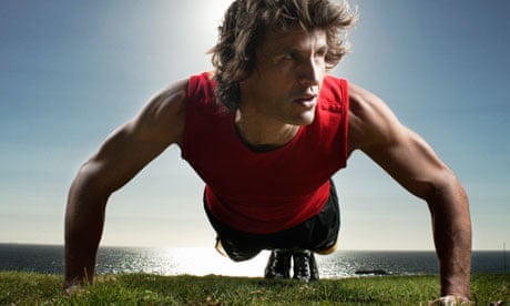 Man doing pressups on the grass by the sea