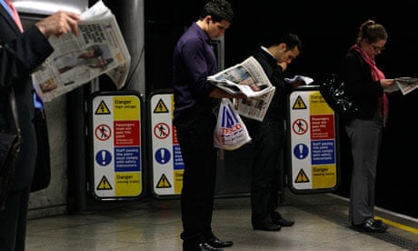 Commuters read London evening papers