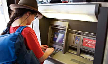 Woman tourist using an ATM machine Seattle USA