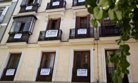 Signs saying "For Sale" hang on balconies  
