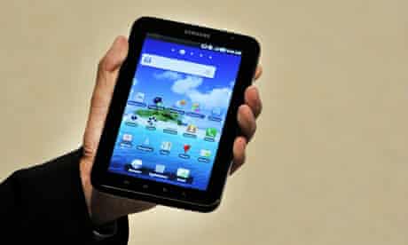 A hand holds up a Samsung Galaxy tablet