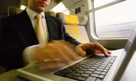 Man on train working on computer