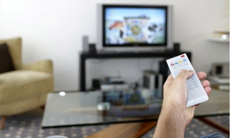A man watching TV using a remote control