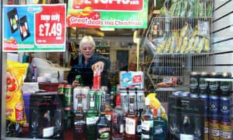 A shopworker stacks alcohol at a store in Govan, Glasgow
