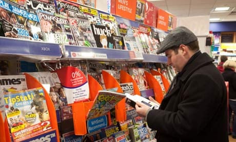A man looking at magazines in WH Smiths, Cambridge UK