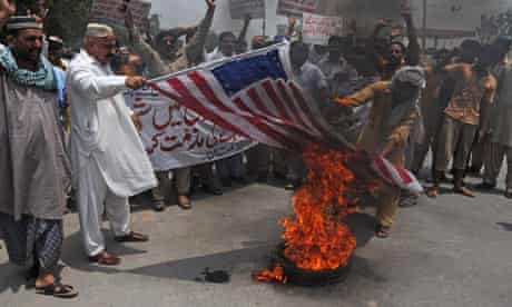 Pakistani protesters burn a representation of an American flag