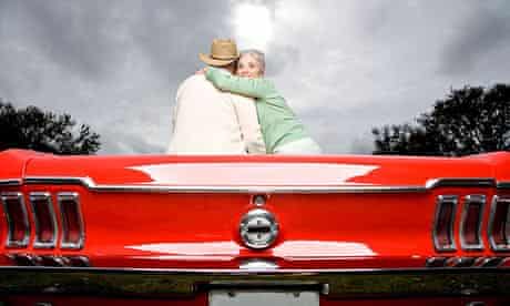 A senior couple in a sports car