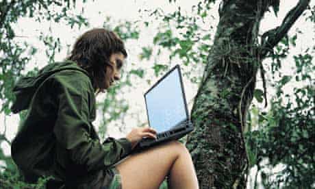 Woman working on a laptop up a tree