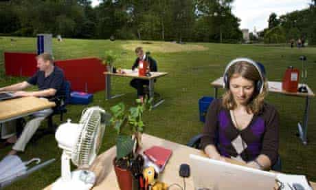 Office workers sit at desks outside