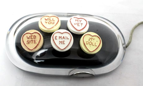 Love heart sweets on a computer mouse.