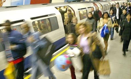 Commuters leave a London Underground train at Green Park Underground station in London