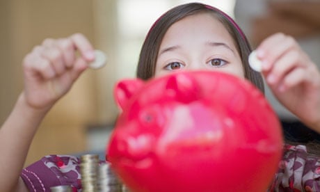 A girl putting money in a piggy bank