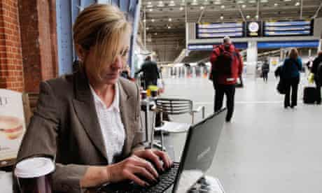A woman using a laptop in a train station