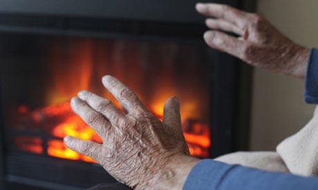 An older woman warming her hands in front of a fire
