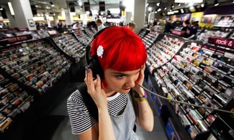 A womnan listening to music on headphones in HMV, London