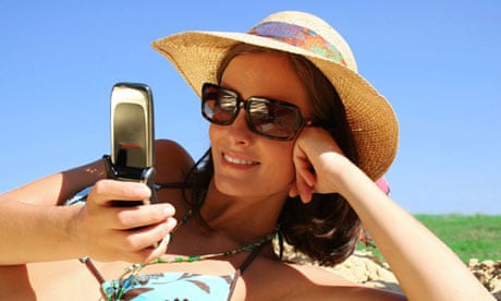 A woman using a mobile phone on the beach