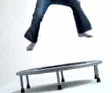 A child leaping through the air jumping on a trampoline bouncing up and down