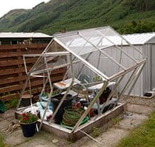 Green house lies destroyed after wind damage in a garden