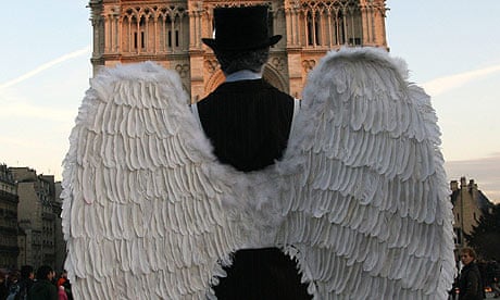 A mime wears angel wings outside Notre Dame in Paris