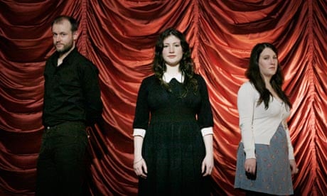 Adrian McNally with Rachel and Becky Unthank in front of red satin drapes