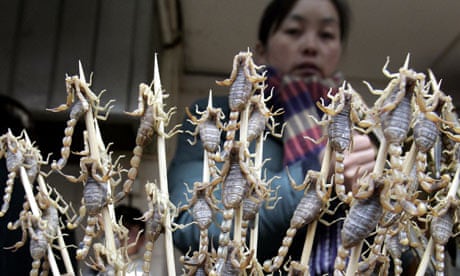 A Chinese woman selling scorpions on stick