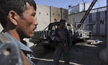Afghan policemen keep watch near the wre