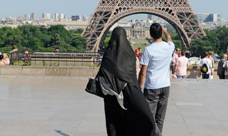 A woman wearing niqab walks at Square Trocadero near the Eiffel Tower in Paris