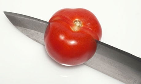 knife cuts through tomato