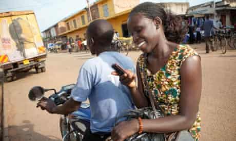 Ugandan woman texts on motorcycle taxi