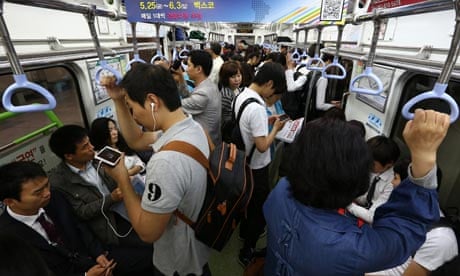 commuters on smartphones in South Korea