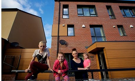 Justine Hutton and her children pose outside their passive house in Oldham