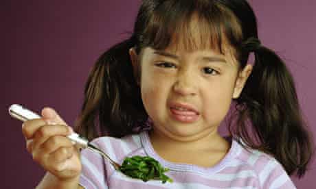 Girl making face at spinach