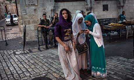 Arab women watched by Israeli soldiers in Jerusalem