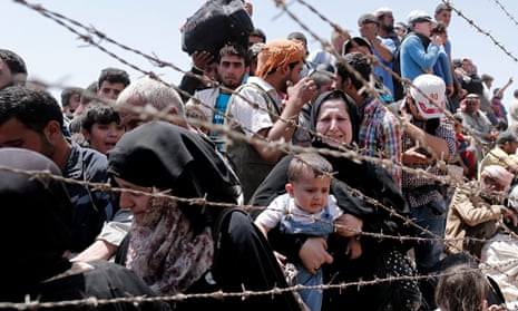 Syrian refugees wait to cross the border into Turkey.  Samar Yazbek crossed the other way…