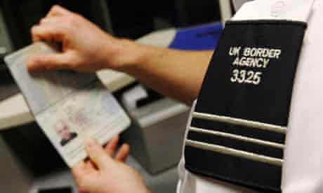 A UK Border Agency worker poses with a passport  