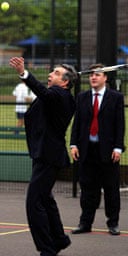 Gordon Brown, watched by Ed Balls, playing tennis at the West London Academy, in London, on July 13 2007. Photograph: Cathal McNaughton/AP/WPA Pool.