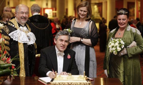 The lord mayor of London, Ian Luder, and his wife, Lin (far right), watch as Gordon Brown signs the distinguished visitors' book, while his wife Sarah stands behind him, in the Guildhall in London on November 10 2008. Photograph: Shaun Curry/PA Wire