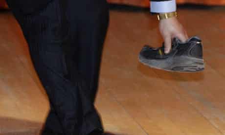 A security guard picks up a shoe that was thrown at Chinese premier Wen Jiabao on February 2 2009