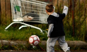 Young boy playing football in the street