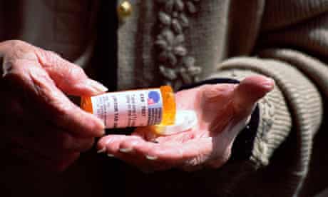 Elderly woman opening bottle of cholesterol pills medication