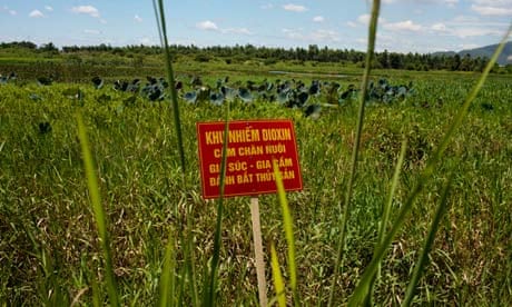 A warning sign stands in a Vietnam field contaminated with dioxin